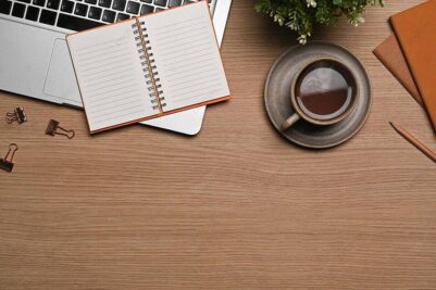 Escritorio con portátil, taza de café y documentos para la gestión del Modelo 130