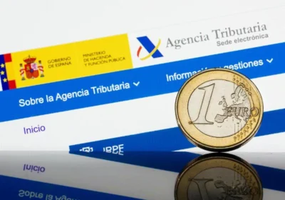 Campaña de renta 2024: moneda de un euro frente a la sede electrónica de la Agencia Tributaria.