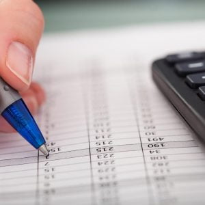 Asesor fiscal de Lam revisando la documentación para la declaración del IMPUESTO SOBRE SOCIEDADES de un cliente